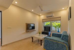 莫尔穆冈Lavish Apartments with Swimming Pool near Candolim Beach的带沙发、桌子和电视的客厅