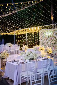 塔林甘海滩Conrad Koh Samui的一张桌子,用来举办婚礼,上面有白色的桌子和椅子