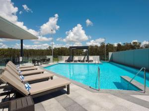 布里斯班布里斯班机场普尔曼酒店的一个带躺椅的游泳池