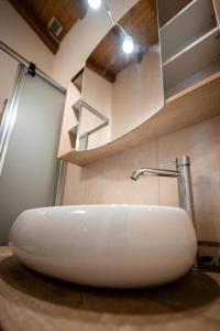沃卡罗Art Apartment Ticino的浴室设有白色水槽和镜子