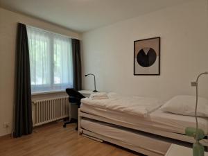 圣莫里茨Apartment Via Surpunt - Ruben- 5 Rooms的一间卧室配有一张床、一张书桌和一个窗户。