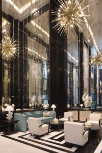 多哈Waldorf Astoria Doha West Bay的大堂设有桌椅和吊灯。