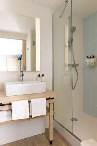 图尔Hampton by Hilton Tours Centre, France的一间带水槽和淋浴的浴室