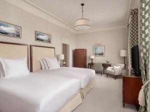 伦敦Raffles London at The OWO的酒店客房设有两张床和电视。
