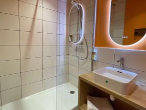 卡斯泰greet hotel Castets Coeur des Landes的一间带水槽和淋浴的浴室