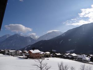OberlienzFerienhaus Mattersberger的山地下雪的村庄