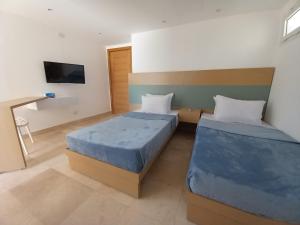 赫尔格达Nayah Stays, Ground terraces Studio的酒店客房配有两张床和一张书桌
