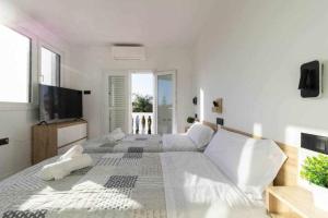 圣巴托洛梅Villa Sofía Maspalomas的白色卧室设有一张大床和电视。