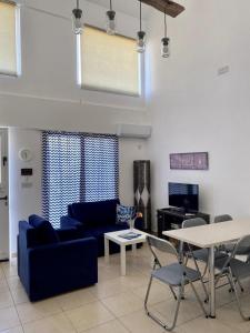 凯里尼亚Loft with Garden 4 min to Beach in Kyrenia的客厅配有蓝色的沙发和桌子