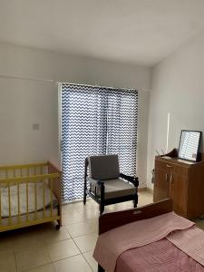 凯里尼亚Loft with Garden 4 min to Beach in Kyrenia的卧室配有床、椅子和窗户。