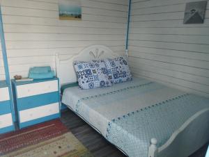 茹里洛夫卡Blue Bungalow Jurilovca的一间卧室配有一张床和一个带白色四柱床的床头柜。