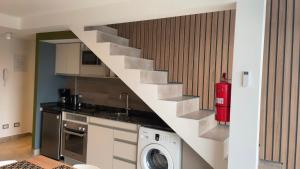 乌斯怀亚Miras Apartment Ushuaia的一间带楼梯和洗衣机的厨房