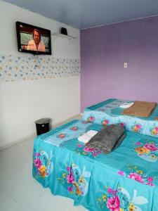 贝伦Hostel das Flores的一间设有床铺的客房,墙上配有电视