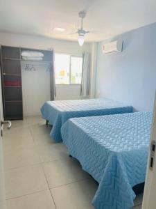 阿拉亚尔-杜卡布Golden Lake Arraial do Cabo Resort的两张位于酒店客房的床,配有蓝色床单