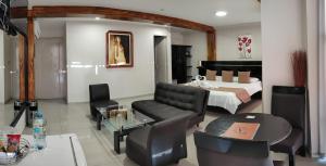齐克拉约Aura Hotel的客厅配有床和桌椅