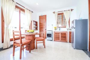 江比阿Babu Villas的厨房配有桌椅和冰箱。
