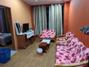 古晋Home Sweet Home的客厅配有粉红色的沙发和电视