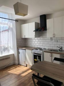 科克Beautiful 1-Bed Apartment in Cork的厨房配有白色橱柜、桌子和炉灶。
