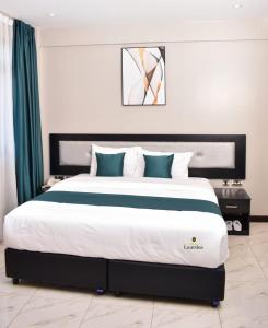 SiayaHotel Lourdes, Siaya的一间卧室配有一张带蓝白色枕头的大床