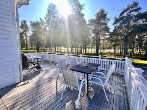 吕勒奥Riverfront Cosy Villa in Luleå的木制甲板上配有桌椅