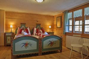 圣安特尼恩Gasthaus Bellawiese的一间卧室配有红色枕头的床