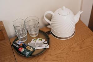 维尔纽斯CATHEDRAL HOTEL Self-check in的茶壶和玻璃杯的桌子