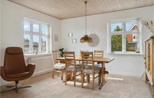 Ryomgård2 Bedroom Cozy Home In Ryomgrd的一间带木桌和椅子的用餐室