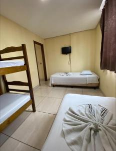 迪维诺波利斯Pousada Elita的客房设有两张床和一张双层床。