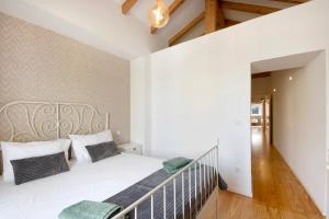 孔迪镇Lidador House Vila do Conde的卧室配有白色的床和楼梯。