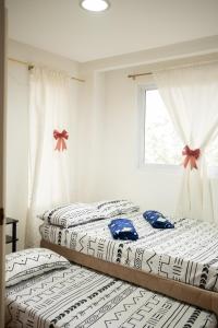 碧瑶The Greens Home & Garden - ENTIRE 3RD FLOOR的带窗户的客房内设有两张单人床。