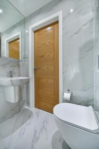 伦敦Queens Park Premier London Hyde Park的白色的浴室设有卫生间和水槽。