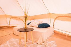 切尔韦纳沃达Glamping U hranic的帐篷内带一张床位的房间,配有一张桌子