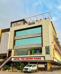 PātanHotel The Grand Piano - Best Business Hotel in Patan的前面有停车位的建筑