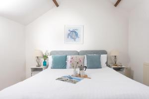 卡比斯贝Laity Vean Hideaway的卧室配有带蓝色枕头的大型白色床