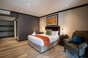 温特和克阿勒布什旅行酒店的配有一张床和一把椅子的酒店客房
