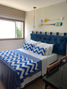 维拉维尔哈Suíte Itaipu Mar的一间卧室配有一张带蓝色和白色棉被的床