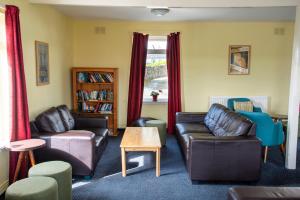 柯克沃尔Kirkwall Youth Hostel的客厅配有两张沙发和一张桌子