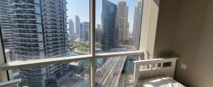 迪拜"Luxurious 2 Bed, 3 Bath Apartment in Dubai Marina - Steps Away from JBR!"的卧室设有大窗户,享有城市美景