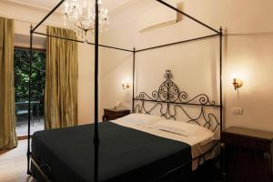 坎特洛麦当娜餐厅酒店的卧室里一张黑色天蓬床,设有窗户