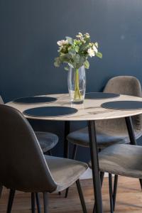 爱丁堡Modern 2BED Apartment-Free Parking的花瓶坐在桌子上,摆放着椅子
