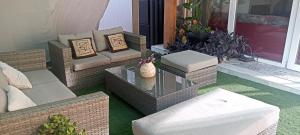 格拉纳达Home & garden suites center Granada的门廊上设有带藤椅和桌子的庭院