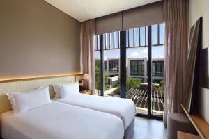 帕福斯Minthis Resort的配有大窗户的酒店客房内的两张床