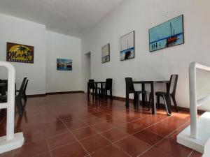博卡奇卡Calypso Beach Hotel by The Urbn House Santo Domingo Airport的一间用餐室,配有黑色椅子和桌子