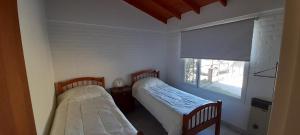玛德琳港Los Choiques Madryn的小型客房 - 带2张床和窗户