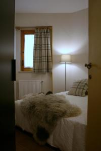 RovereAppartamento Arnolucci的卧室配有白色床和毛绒地毯