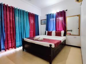 巴加Ivy Retreat- Serviced Apartments的一间卧室配有色彩缤纷的窗帘