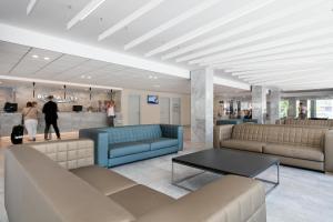 萨洛圣地亚哥最佳酒店的大厅里,在商店里摆放着长沙发和桌子