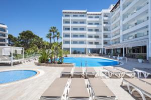 萨洛Hotel Best Punta Dorada的一座带躺椅的游泳池和一座建筑