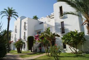 莫哈卡尔普韦布洛英达洛度假俱乐部最佳酒店的一座白色的建筑,前面有棕榈树