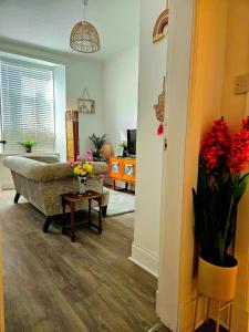 DarvelThe Ferns - Shared Garden Apartment With Parking的客厅配有沙发和鲜花桌